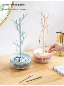 Detail of pink and blue jewelry rack with branch hanger and rotating tray organizer