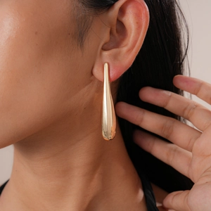 Close-up of elegant gold teardrop earrings with a polished finish on female model