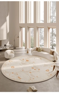 Close-up of a soft round beige carpet with orange abstract patterns in a living room