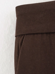 Detailed close-up of dark brown twill fabric texture and professional sewing on the suit