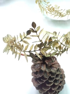 Macro detail of golden olive leaf crown showing engraved leaf texture and metal finish
