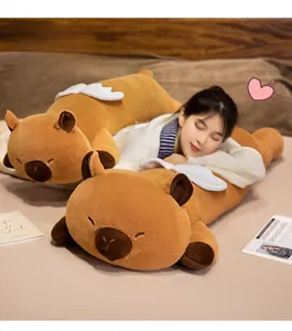 Detail of soft capybara plush pillow with angel wings shown in a cozy bedroom setting
