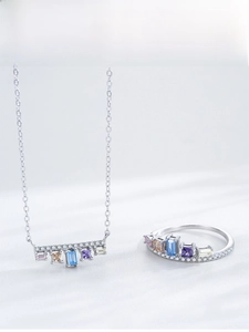 Detailed close-up of a silver jewelry set featuring a multi-colored gemstone crown ring