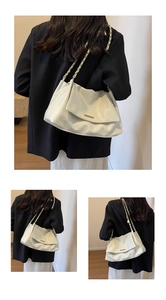 Detail of creamy white PU tote with pleated texture and gold chain strap accents
