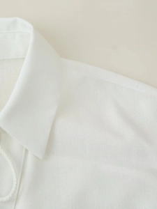 Close-up of lapel and shoulder details on white linen blend casual shirt