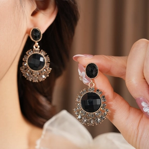Détail de boucles d'oreilles fleurs vintage avec pierres noires et petits diamants