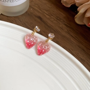 Detail of pink resin strawberry earrings with sparkling zircon and gold metal accents