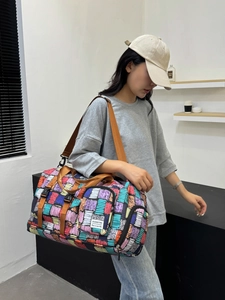 Large capacity travel bag with colorful geometric patterns and adjustable shoulder strap