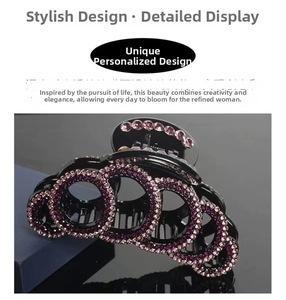 Detailed view of large hair claw clip with pink and purple rhinestones on black acrylic