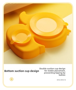 Detail view of the yellow silicone baby plate showing secure suction cups on the bottom