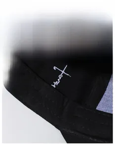 Detail of moisture-wicking sweatband and white embroidery inside the black baseball cap