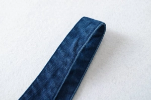 Detailaufnahme der Nähte und Denim-Textur dieses blauen figurbetonten Kleides
