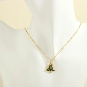 Detailed close-up of a golden Christmas tree pendant with green enamel and colored crystals