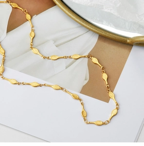 Detailed macro view of gold-plated oval mesh chain link necklace with tennis racquet texture