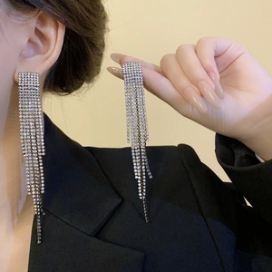 Détails de boucles d'oreilles à pampilles argentées avec de longues chaînes en strass