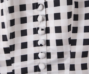 Close-up of black and white plaid dress fabric with matching fabric-covered buttons
