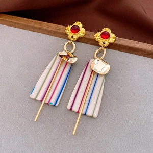 Detail of vintage resin earrings with gold flower top and colorful striped rectangular pendant