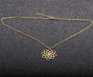 Détail du collier pendentif fleur de lotus doré avec fermoir sur fond sombre