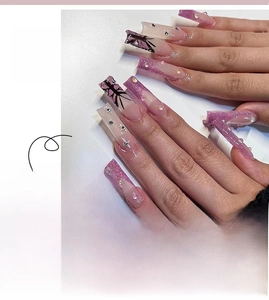 Detailed view of long coffin French press-on nails with butterfly art and rhinestones