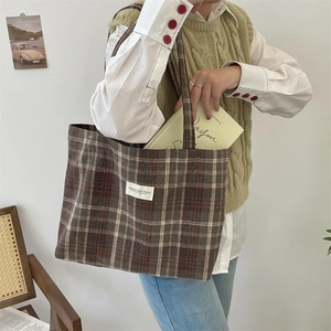 Retro brown plaid wool tote bag worn over the shoulder by a model in a cozy setting