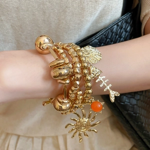 Bohemian gold-layered bracelet set with metal beads, shell, and sun charms for women