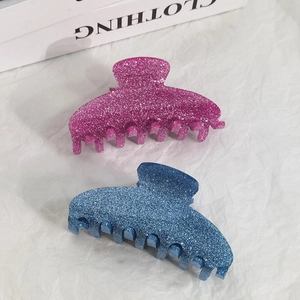 Glitter acrylic shark hair clips in pink and blue colors on a clean white background