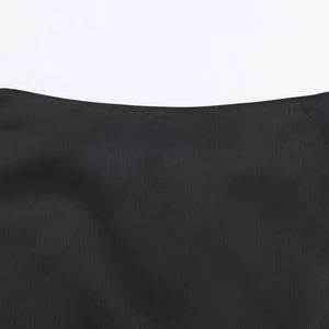 Elegant black pleated skirt-pants featuring delicate lace hem and vertical texture