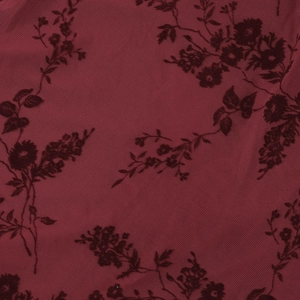 Gros plan sur un tissu en maille dentelle rouge foncé avec motifs floraux floqués