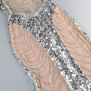Detail of silver sequins and rhinestone chain fringes on a beige sleeveless evening gown