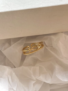Detailed view of a gold double-layer fish ring with textured band and sparkling zircon eye
