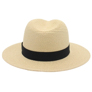 Close-up of beige woven texture and black ribbon band on a classic summer Panama hat