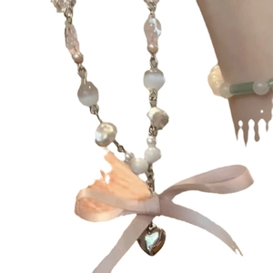 Collier en perles avec nœud en ruban rose et pendentif cœur argenté chic