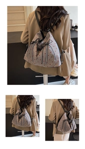 Detail of grey polka dot backpack with triangle structure and leather shoulder straps