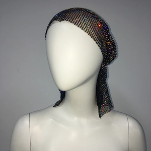 Detail of shimmering multi-color rhinestones on a black mesh long tail headpiece