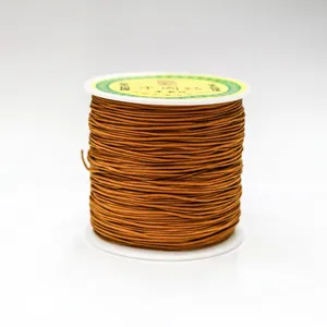 Detailed close-up of 0.8mm brown nylon cord neatly wound on a white plastic spool