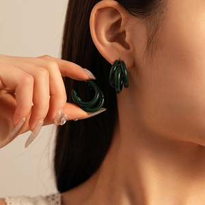 Vue macro de boucles d'oreilles en C multicouches vert foncé avec finition brillante