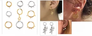 Detailed views of diverse 18K gold and silver hoop earrings with star and angel charms