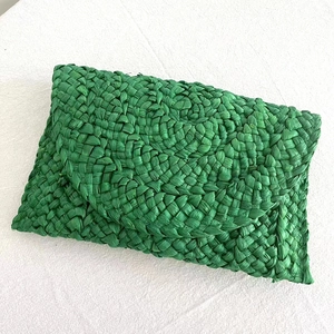 Detailed close-up of green woven paper straw envelope clutch bag with vibrant texture