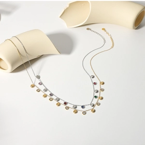 Detail of double-layer 18k gold necklace with shell pendant and zircon stones