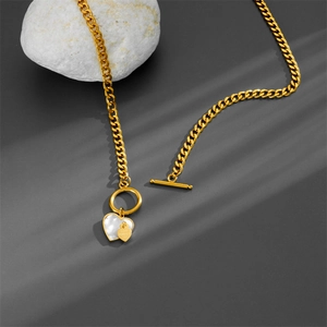 Macro view of gold S925 heart pendant with shell texture and LOVE FOREVER engraving