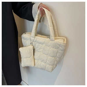 Close-up of cream quilted tote bag with petal pattern and matching small pouch