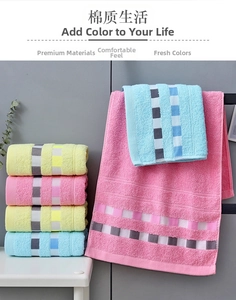 Detail of soft cotton towels with colorful checkered trim in pink, blue and yellow