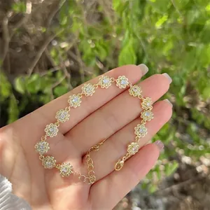 Detailed view of 18K gold plated floral link bracelet with zircons worn on wrist