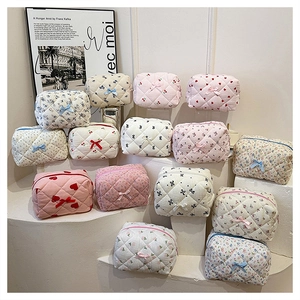 Macro shot of quilted cotton makeup bags in floral and striped patterns with bows