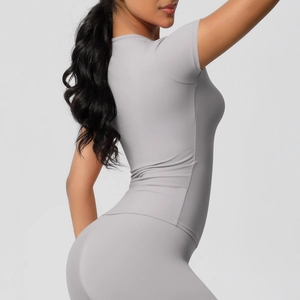 Détail du t-shirt de sport gris ajusté montrant le tissu élastique et la coupe sans couture