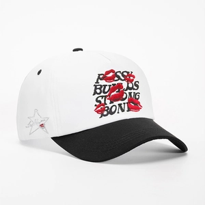 Detail of embroidered lip prints and letter text on contrast color baseball cap