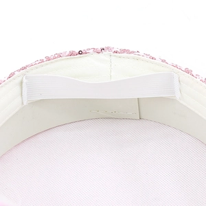 Detail of pink sequin hat showing white elastic strap and inner fabric lining