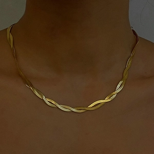 Detail shot of golden multi-layer twisted snake bone chain necklace on female model
