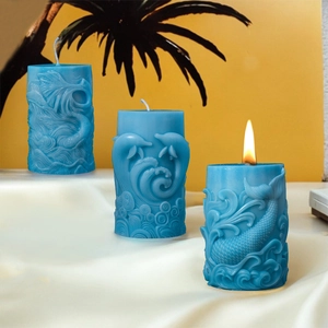 Dettaglio di candele blu intagliate con motivi di delfini e code di sirena