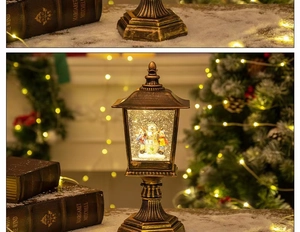 Detail of bronze Christmas street lamp decor with internal snowman scene and warm light